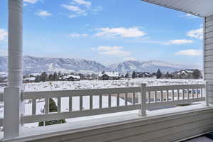 Snow covered deck featuring a mountain view