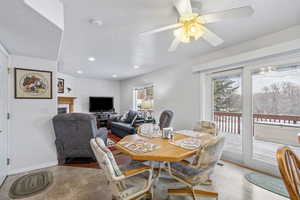 Dining area featuring a healthy amount of sunlight, ceiling fan, a tiled fireplace, and a textured ceiling