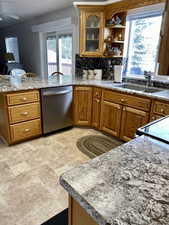 Kitchen with sink, kitchen peninsula, decorative backsplash, and dishwasher