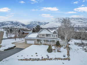 View of front facade featuring covered porch, a garage, and a mountain view