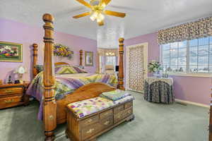 Carpeted bedroom with a textured ceiling and ceiling fan