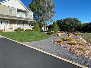 View of front facade featuring a front yard and covered porch