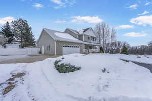 View of property with a garage and covered porch