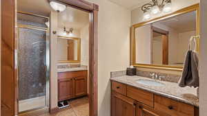 Bathroom with walk in shower, tile patterned flooring, and vanity