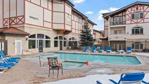 View of pool with a hot tub and a patio