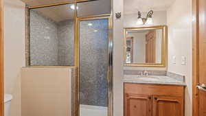 Bathroom with vanity, walk in shower, and toilet