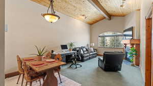 Home office featuring beamed ceiling, high vaulted ceiling, wooden ceiling, and carpet flooring