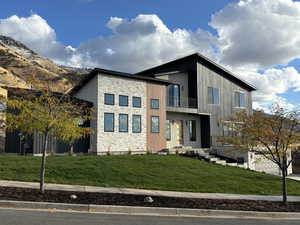 Contemporary home with a balcony and a front yard