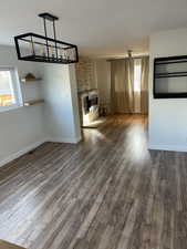 Unfurnished living room with a fireplace, a healthy amount of sunlight, and dark hardwood / wood-style floors