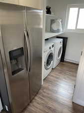 Laundry area featuring washing machine and dryer and light wood-type flooring