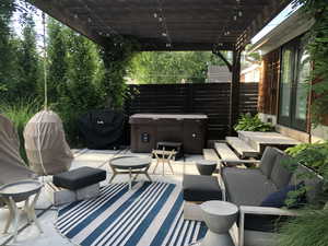 View of patio / terrace with a grill, outdoor lounge area, a hot tub, and a pergola