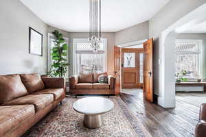 Living room featuring an inviting chandelier and dark hardwood / wood-style floors