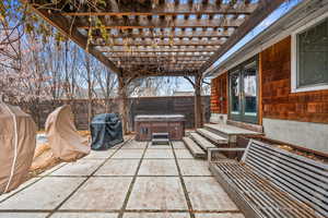 View of patio with grilling area, french doors, a hot tub, and a pergola