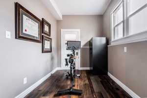 Exercise area with dark wood-type flooring