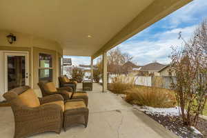 Snow covered patio featuring outdoor lounge area