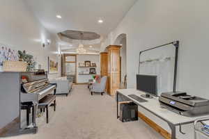 Home office featuring light colored carpet, a tray ceiling, and ornate columns