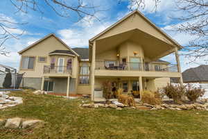 Rear view of property with a trampoline, a yard, and a balcony