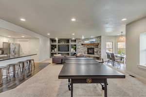 Playroom featuring dark hardwood / wood-style flooring and a stone fireplace