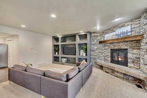 Living room featuring light hardwood / wood-style floors, a fireplace, and built in shelves