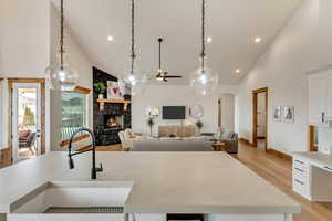 Kitchen featuring white cabinetry, an island with sink, sink, and pendant lighting