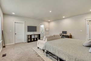 Bedroom with light colored carpet and ensuite bathroom