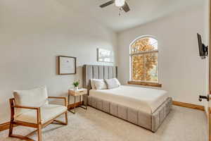 Bedroom with ceiling fan and light carpet