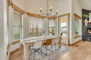 Dining area featuring a chandelier, a fireplace, and light hardwood / wood-style floors