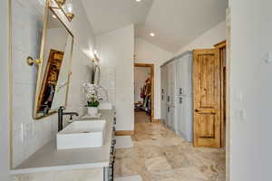 Bathroom featuring lofted ceiling and vanity