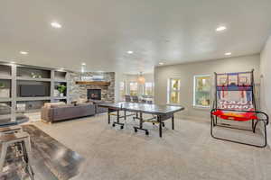 Playroom featuring built in features, a fireplace, and light colored carpet