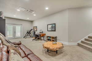 Carpeted living room with french doors