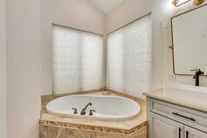 Bathroom featuring vanity and a relaxing tiled tub