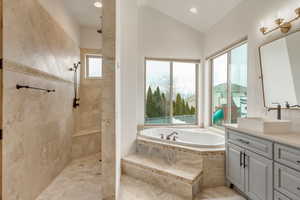 Bathroom with vanity, lofted ceiling, and plus walk in shower