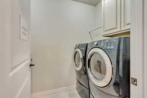 Laundry room with cabinets and washing machine and clothes dryer