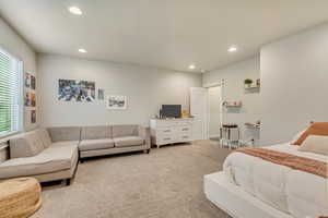 Bedroom featuring light carpet