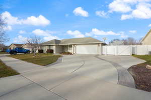 View of front of home with a front lawn and a garage and large driveway