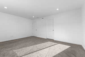 Carpeted spare room featuring visible vents, baseboards, and recessed lighting