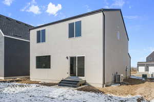 Snow covered back of property with ac unit