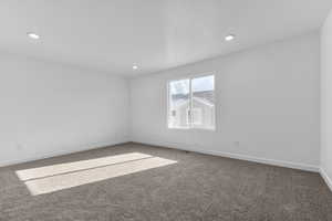 Unfurnished room featuring carpet, baseboards, and recessed lighting