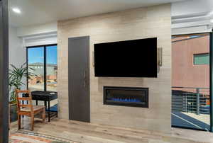 Living room featuring a tiled fireplace and light hardwood / wood-style floors