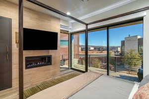 Bedroom with floor to ceiling windows, a fireplace, and access to exterior