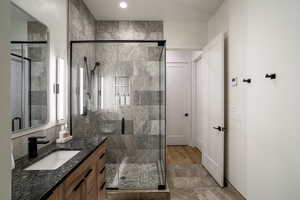 Bathroom featuring a shower with door and vanity