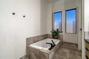 Bathroom featuring vanity and tiled tub