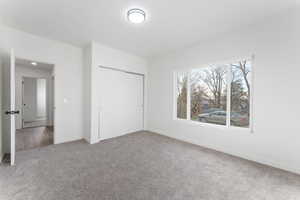 Unfurnished bedroom with a closet and carpet floors