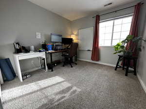 Carpeted office space featuring a textured ceiling