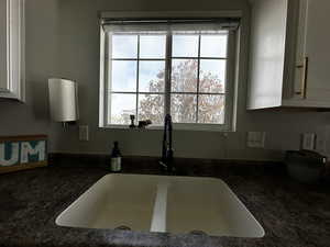 Kitchen featuring white cabinets, plenty of natural light, and sink