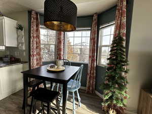 Dining space with dark wood-type flooring and a textured ceiling