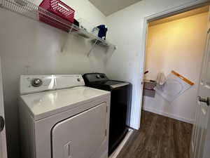 Laundry area with washer and clothes dryer and dark wood-type flooring