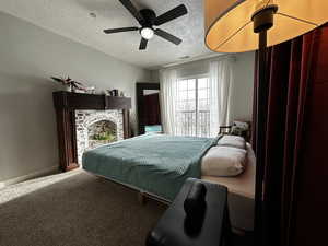 Bedroom with carpet, a textured ceiling, and ceiling fan