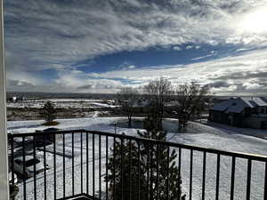 View of snow covered back of property