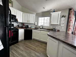 Kitchen featuring white cabinets, dark hardwood / wood-style flooring, sink, and black appliances